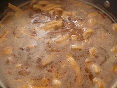 a pot filled with pasta and sauce on top of a stove