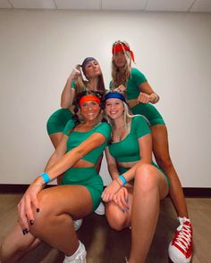 four women in green outfits are posing for a photo with their hands on their hipss