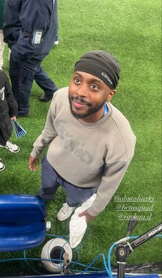 a man sitting on top of a blue cart next to other people in the grass