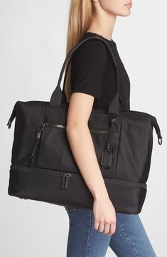 Stay organized with this versatile duffle bag featuring two interior compartments with a quick top zipper that makes it ideal for long weekends and work trips. This bag includes Tumi Tracer®, an exclusive, complimentary program that helps reunite lost or stolen bags with their rightful owners using a one-of-a-kind 20-digit number affixed to the bag Top carry handle; removable, adjustable crossbody strap Quick-access phone pocket; media pocket; water-resistant water bottle pocket; leather card po Travel Duffle Bag With Zipper Pocket And Double Handle, Luxury Travel Bag With Zipper Pocket For Daily Use, Versatile Rectangular Luggage With Zipper Pocket, Elegant Large Capacity Duffle Bag For On-the-go, Luxury Luggage With Zipper Pocket, Rectangular Luggage With Zipper Closure, Luxury Duffle Bag With Zipper Pocket For Daily Use, Modern Travel Bag With Zipper Pocket For Trips, Luxury Travel Satchel With Zipper Pocket