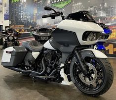 a white and black motorcycle on display in a showroom with other motorcycles behind it