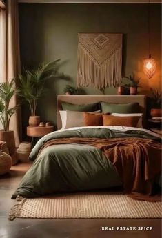 a bed with green sheets and pillows next to a potted plant in the corner