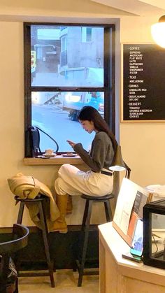 a woman sitting in a chair looking at her cell phone and writing on the screen