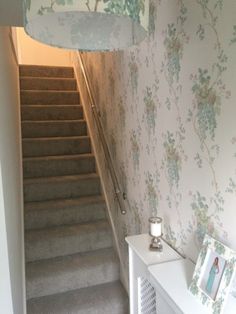 a stairway leading to a bedroom with floral wallpaper