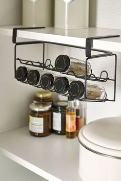 a kitchen shelf with spices and jars on it