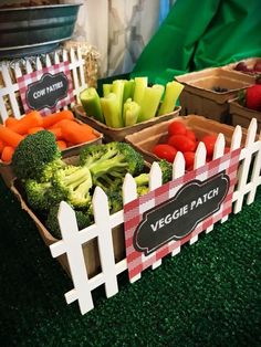 fresh vegetables are displayed in boxes on the table