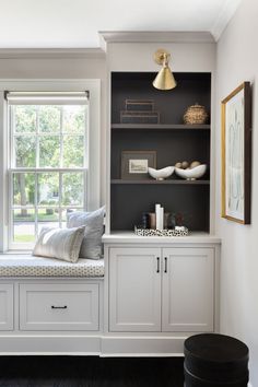 a window seat in the corner of a room with built - in bookshelves