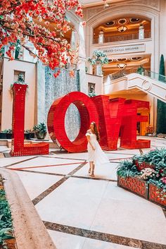 a woman standing in front of a giant love sign