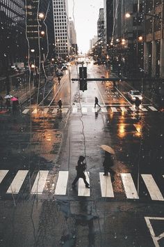 people are crossing the street in the rain