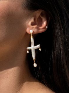 Influenced by the grandeur of Byzantine jewelry and the serene interiors of California's Spanish Missions, these earrings encapsulate both grand and graceful elements. Each earring showcases a cross-shaped pearl, creating a dramatic presence that coexists with the tenderness of a bride on her wedding day. These earrings are a reminder of heritage and love, destined to add a touch of history to your most cherished moments 75” length Freshwater Pearls 14K Gold Filled Posts and wire Please Note - Freshwater Pearls & Gemstones are all natural and therefore unique, your Adorn Pili piece will be a one of one design. Elegant Pierced Cross Jewelry, Elegant Pierced Cross Earrings, Elegant Cross Pendant Earrings, Elegant Pearl Drop Cross Jewelry, Elegant White Cross Earrings, Elegant Cross Pendant Jewelry For Pierced Ears, Byzantine Jewelry, Gold Piece, Pearl Gemstone