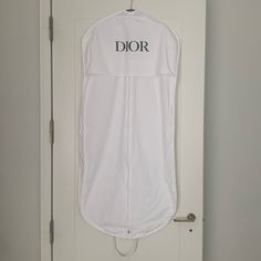 a white garment hanging on a door with the word dior printed on it's side