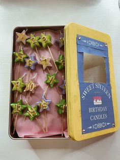 a box filled with lots of little stars on top of a table next to a cupcake