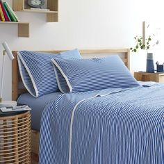 a bed with blue and white striped sheets