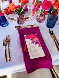 the table is set with pink and orange flowers