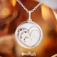 two hearts in the center of a glass pendant on a silver chain with an inscription milkies