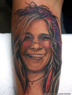 a close up of a person's leg with a tattoo on it and glasses