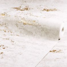 a roll of toilet paper sitting on top of a white floor covered in brown dirt