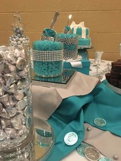 a table topped with lots of candy and candies on top of glass dishes covered in frosting