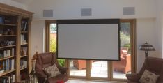 a living room with two chairs and a projection screen