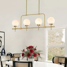 a white dining room table and chairs with red roses