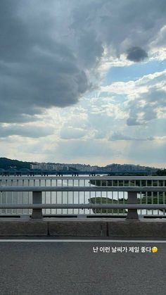 an image of a cloudy sky over the water and bridge that is going to be built in south korea