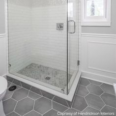 a white tiled bathroom with a walk in shower