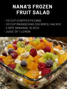 a glass bowl filled with fruit salad on top of a counter