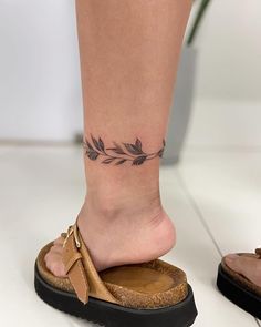 a woman's foot with a small tattoo on her left ankle and an open toe sandal