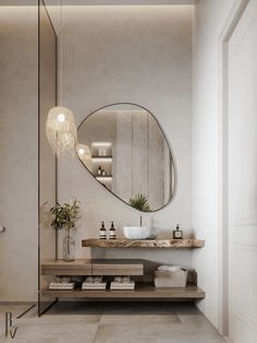 a bathroom with an oval mirror above the sink and two vases on the counter