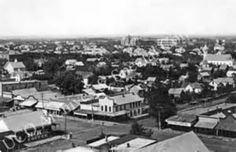 an old black and white photo of a town with lots of houses in the background