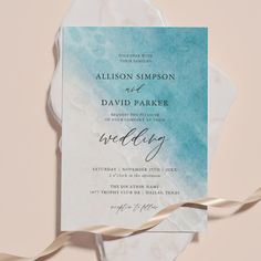 the wedding card is on top of a piece of paper with a ribbon around it