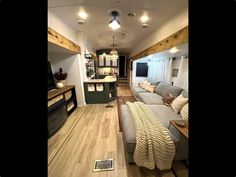 a living room filled with furniture and a flat screen tv on top of a wooden floor