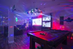 a pool table in a room with red and blue lights