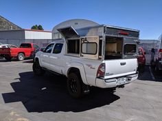 a white truck with a camper attached to it's back in a parking lot