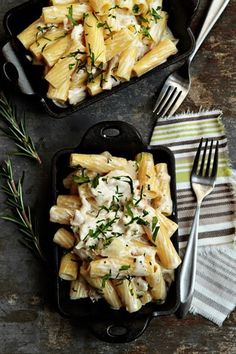 two black pans filled with pasta and chicken