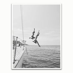 two people jumping off the side of a boat into the ocean