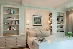 a bedroom with built - in bookshelves and white furniture, including a bed