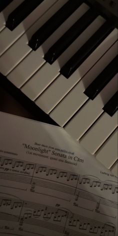 sheet music sitting on top of an open piano keyboard with the words moonlight songs in c minor