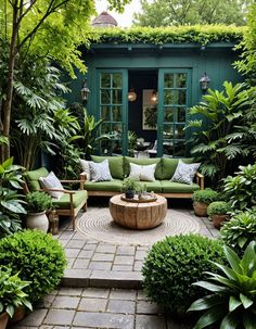 an outdoor living area with green furniture and potted plants