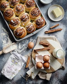 cinnamon buns with icing on a plate next to other ingredients