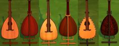 four guitars are lined up against a green wall, each with different shapes and sizes