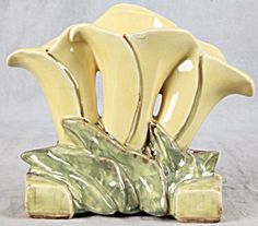 a yellow vase with three bananas on it