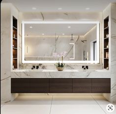 a bathroom with marble counter tops and large mirror above the sink, along with two vases filled with flowers