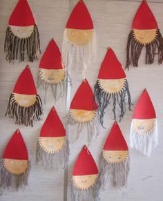 a group of little red hats hanging on a wall