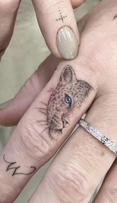 two people with matching tattoos on their fingers, one has a cat and the other has a dog