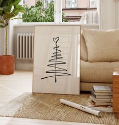 there is a picture frame with a christmas tree on it next to some books and a plant