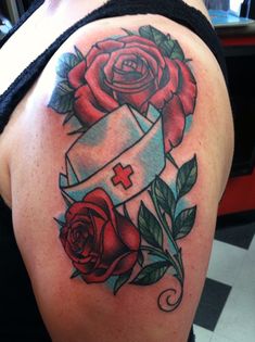 a woman's shoulder with roses and a cross on it