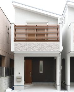 two story white house with wooden slats on the front and second story above it