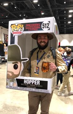 a man with a hat and beard holding a pop vinyl figure in a cardboard box