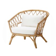 a wicker chair with white pillows on it